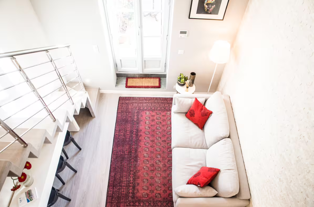 Appartement Airbnb à Nice : salon lumineux avec canapé blanc et tapis rouge